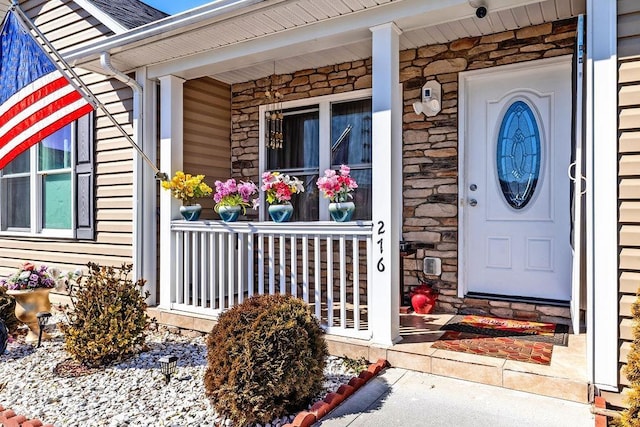 entrance to property featuring stone siding and covered porch