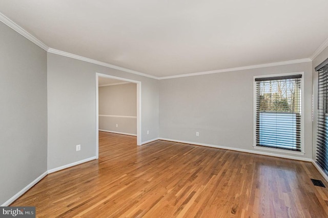 unfurnished room featuring light wood-type flooring, visible vents, crown molding, and baseboards