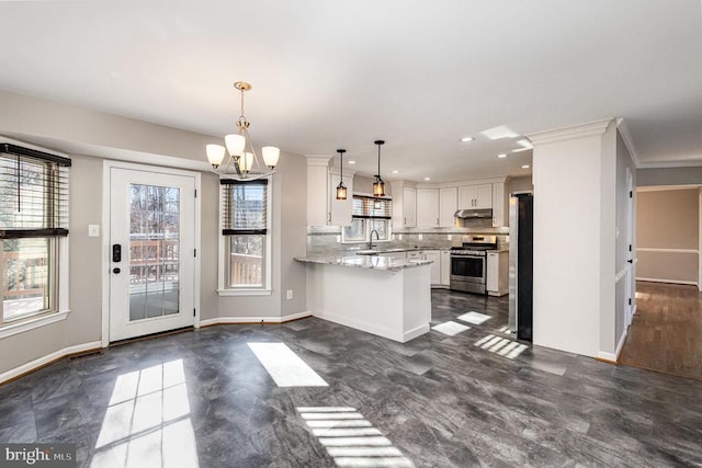 kitchen with hanging light fixtures, appliances with stainless steel finishes, white cabinets, a peninsula, and under cabinet range hood