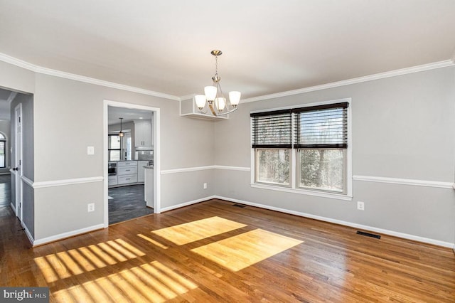 unfurnished dining area with visible vents, baseboards, and wood finished floors