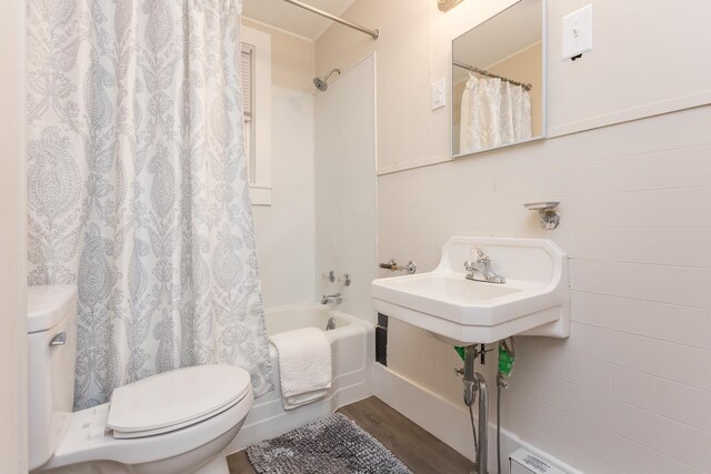 bathroom featuring hardwood / wood-style flooring, shower / tub combo with curtain, and toilet