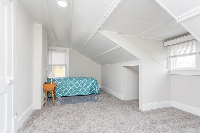 carpeted bedroom with lofted ceiling