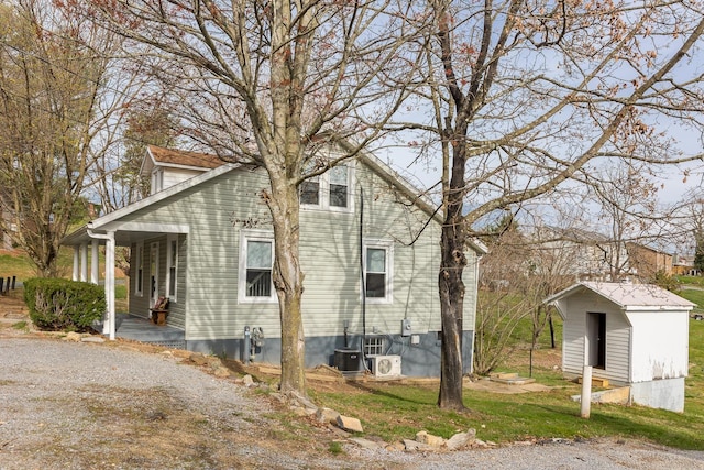 view of property exterior featuring cooling unit and a storage shed