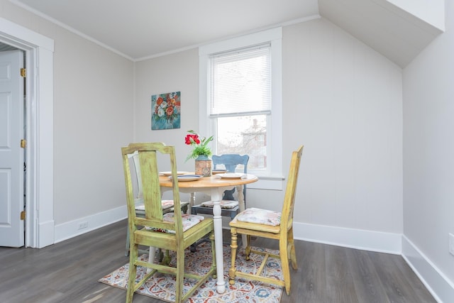 dining space with ornamental molding, dark hardwood / wood-style floors, and vaulted ceiling