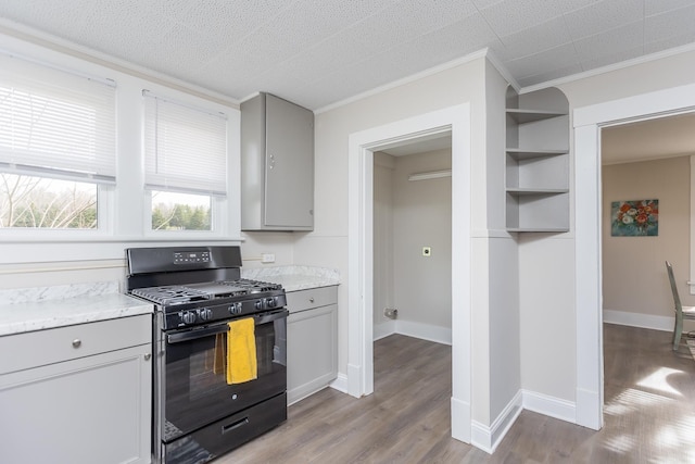 kitchen featuring gray cabinets, light wood-type flooring, black range with gas stovetop, crown molding, and a textured ceiling