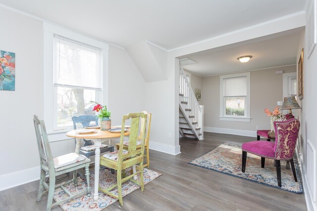 dining area featuring ornamental molding, a healthy amount of sunlight, and dark wood-type flooring