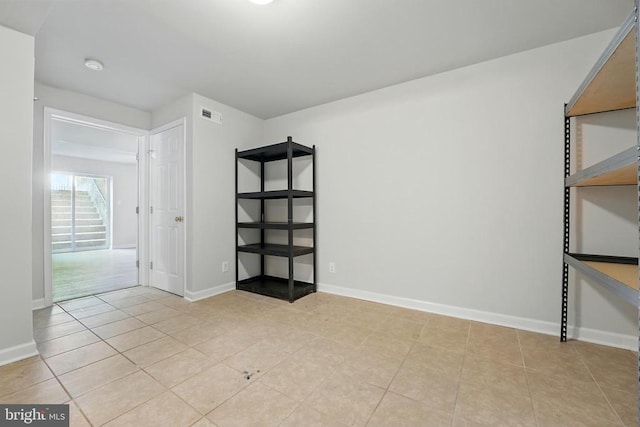 empty room with visible vents, baseboards, and light tile patterned floors