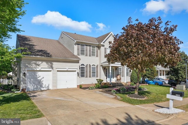 colonial house with an attached garage, a front lawn, roof with shingles, and driveway