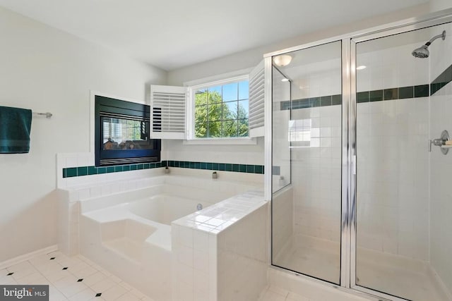 full bathroom featuring tile patterned floors, baseboards, a shower stall, and a garden tub
