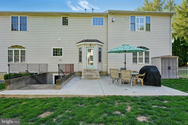 rear view of house featuring a patio, a storage unit, an outbuilding, entry steps, and a yard