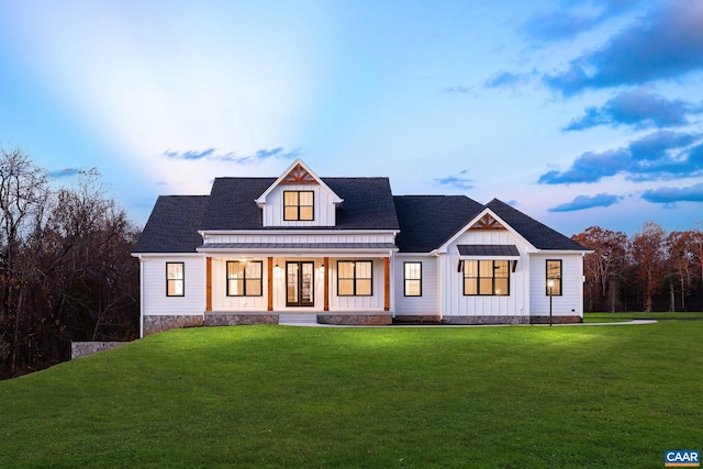 modern farmhouse featuring a yard, board and batten siding, and a porch