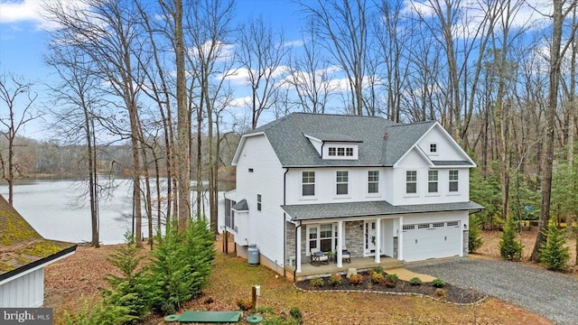 view of front facade featuring a water view, a porch, and a garage