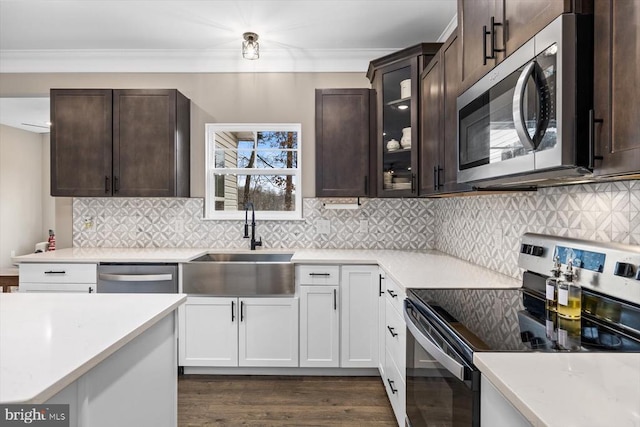 kitchen featuring sink, stainless steel appliances, white cabinets, dark hardwood / wood-style flooring, and decorative backsplash