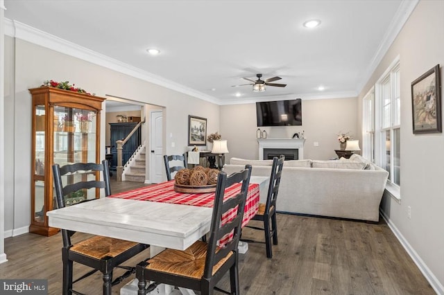 dining space with crown molding, ceiling fan, and dark hardwood / wood-style flooring