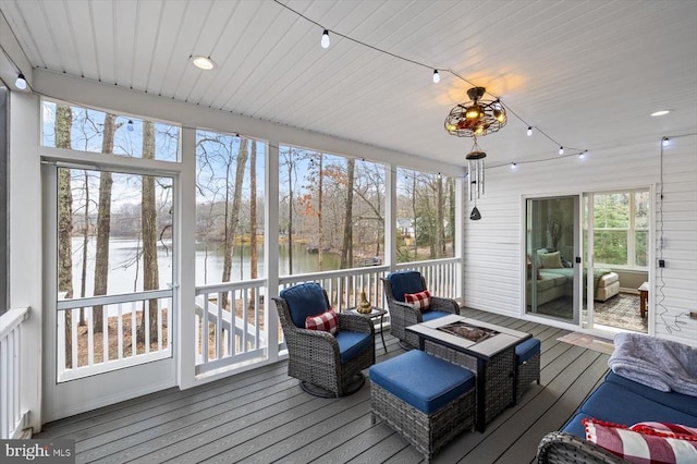 sunroom / solarium featuring a water view