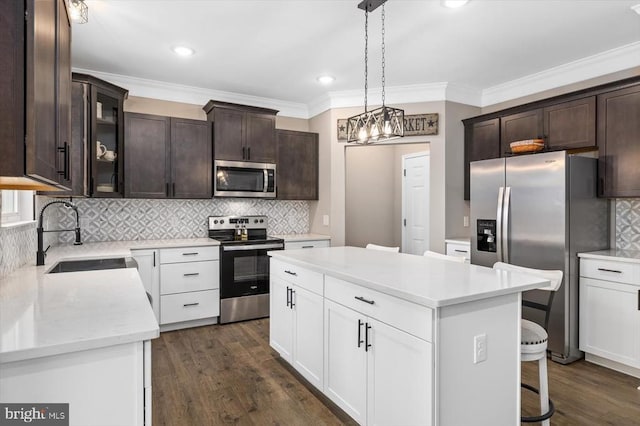 kitchen with a kitchen island, white cabinetry, sink, dark hardwood / wood-style flooring, and stainless steel appliances