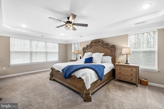 bedroom featuring a tray ceiling, ceiling fan, and carpet