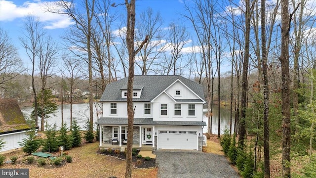 view of front of property featuring a garage, a water view, and covered porch