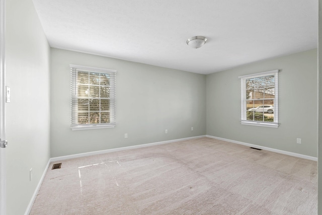 carpeted empty room with baseboards and visible vents