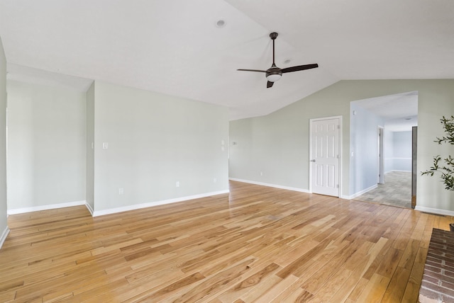 spare room featuring ceiling fan, baseboards, lofted ceiling, and light wood-style floors