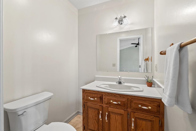 half bathroom featuring vanity, tile patterned floors, toilet, and baseboards