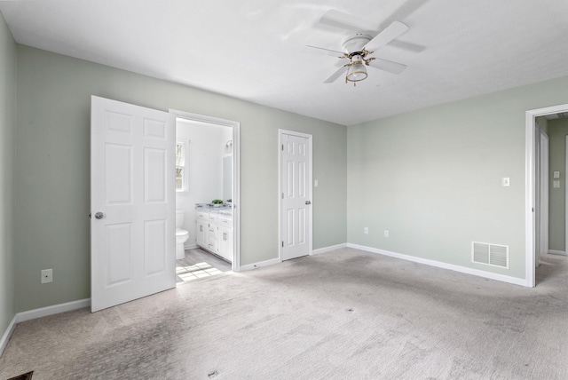 unfurnished bedroom with visible vents, light carpet, a ceiling fan, ensuite bath, and baseboards