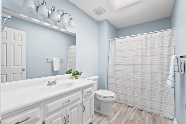 full bathroom featuring vanity, toilet, wood finished floors, and visible vents