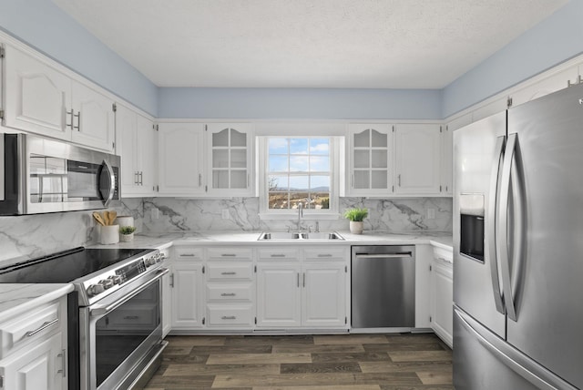 kitchen featuring dark wood-type flooring, backsplash, appliances with stainless steel finishes, and a sink