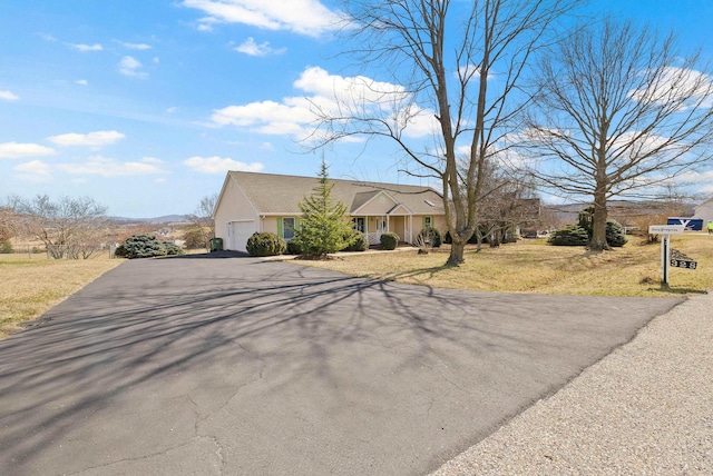 ranch-style house with a garage, a front lawn, and aphalt driveway