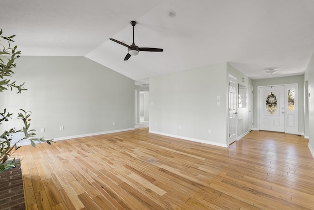 unfurnished living room featuring light wood-style flooring, a ceiling fan, baseboards, and vaulted ceiling