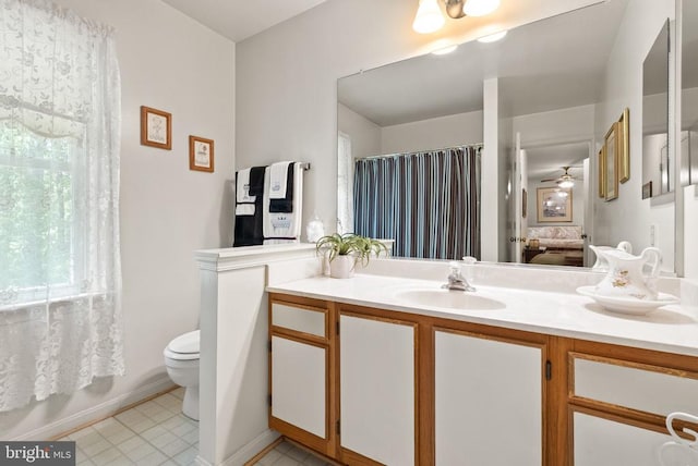 bathroom featuring vanity, baseboards, curtained shower, and toilet