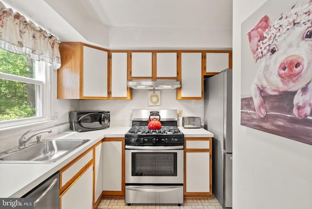 kitchen featuring light countertops, stainless steel appliances, extractor fan, and a sink