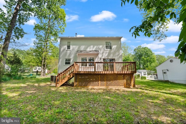 rear view of house with a wooden deck, a yard, and stairway