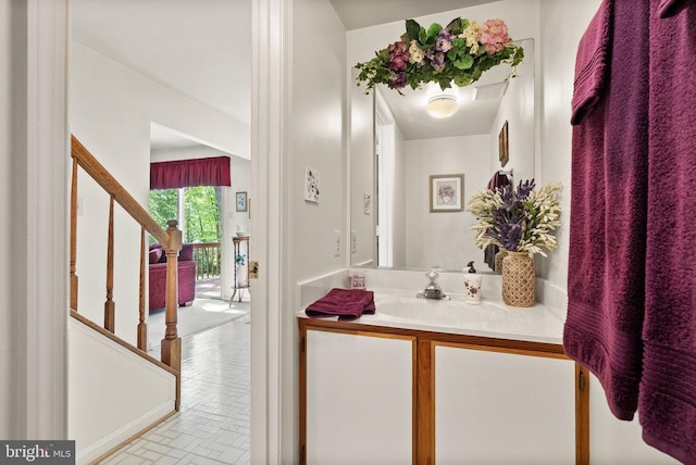 bathroom with vanity and brick patterned floor