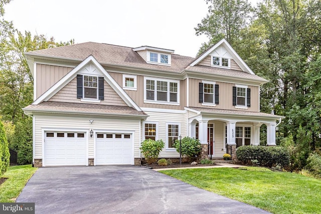 view of front of property with aphalt driveway, a front lawn, and a shingled roof