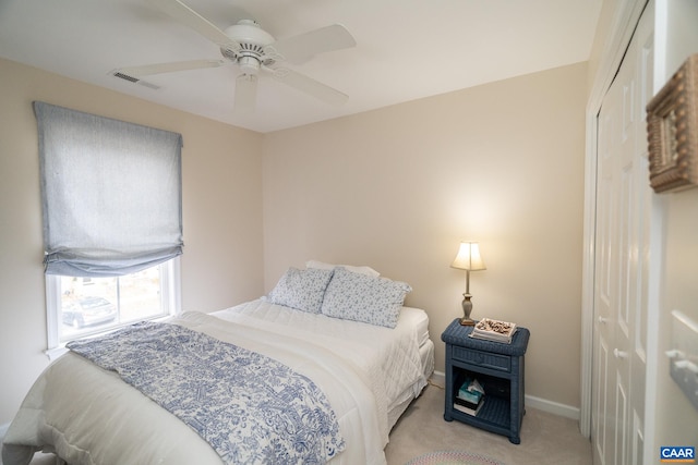 carpeted bedroom with ceiling fan and a closet