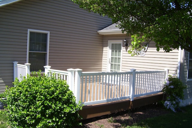 property entrance featuring a deck and a shingled roof