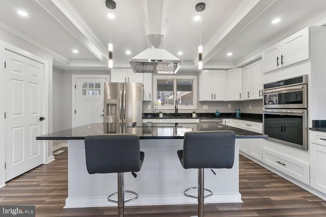 kitchen with stainless steel appliances, pendant lighting, white cabinetry, and a kitchen island