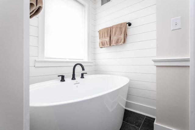 bathroom with tile patterned flooring, visible vents, and wood walls