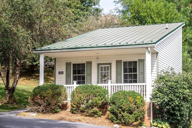 view of front of home with a standing seam roof, a porch, and metal roof