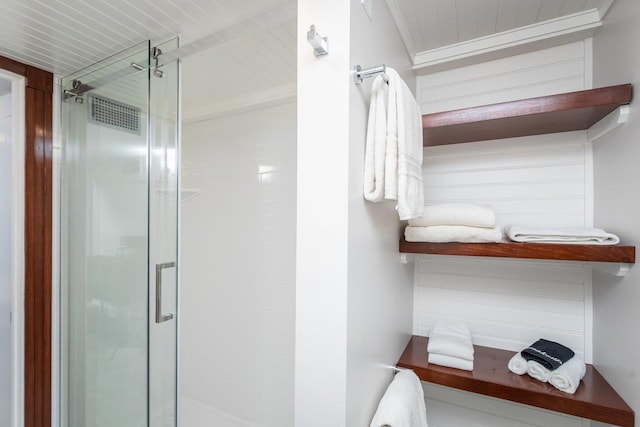 bathroom with a stall shower and ornamental molding