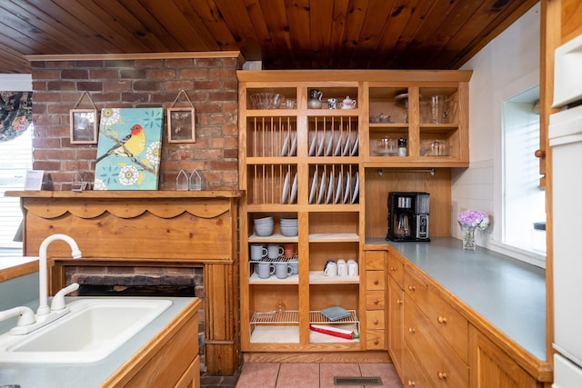 kitchen with tile patterned floors, visible vents, wood ceiling, and a sink