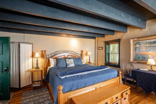 bedroom featuring beam ceiling and wood finished floors