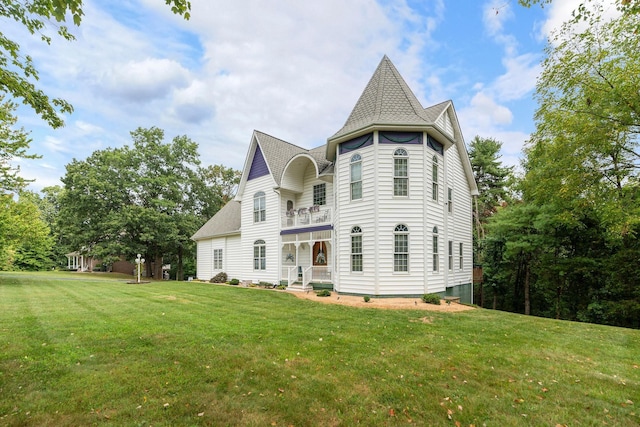 rear view of property with a lawn and a balcony