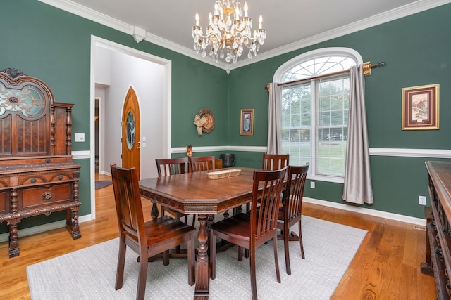 dining space with crown molding, wood-type flooring, and a chandelier