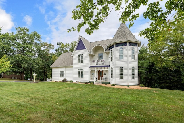 view of front of house with a balcony and a front yard