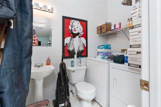 bathroom featuring sink, independent washer and dryer, and toilet