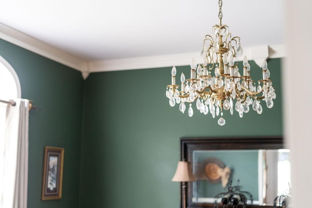 details featuring ornamental molding and an inviting chandelier