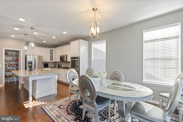 dining room with a wealth of natural light, dark wood finished floors, baseboards, and recessed lighting