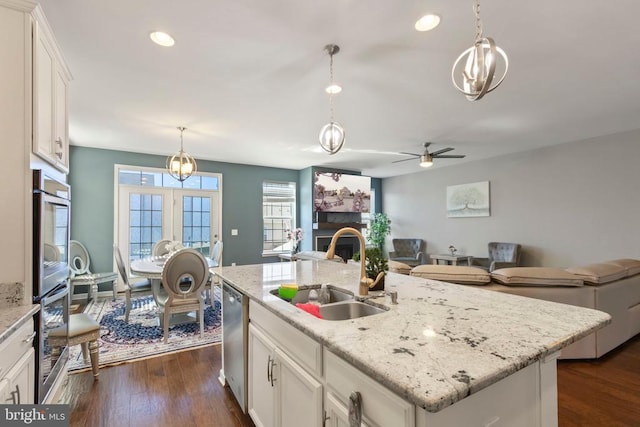 kitchen with open floor plan, white cabinetry, a sink, and an island with sink